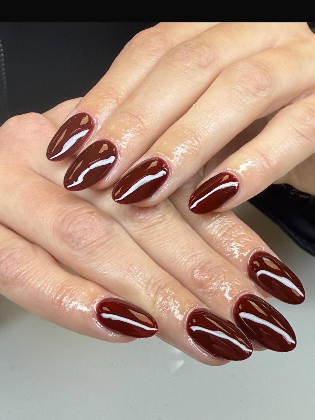 Glanzende bordeauxrode gellak op amandelvormige nagels